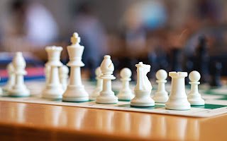 A chess set ready to play on a wooden table
