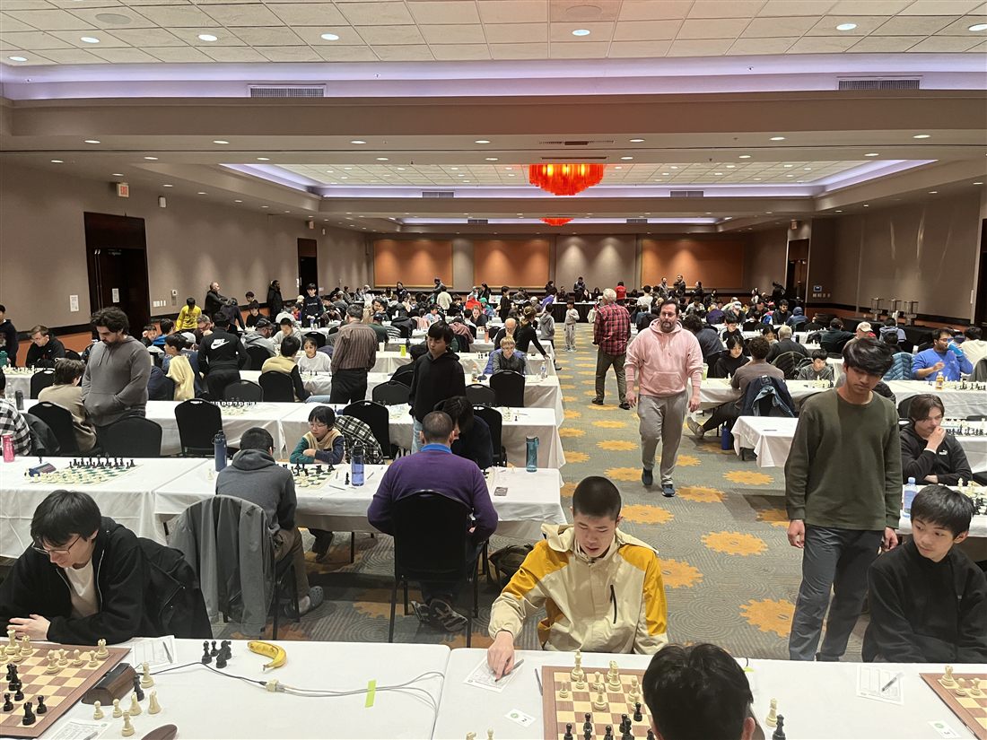 A packed tournament hall full of players at boards